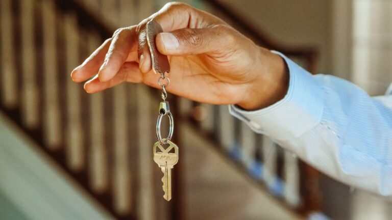 Mão entregando a chave de um apartamento